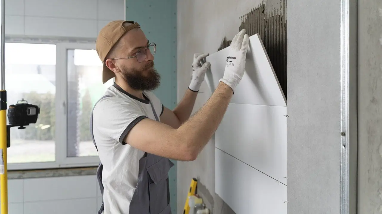 A worker smoothing compound onto a wall