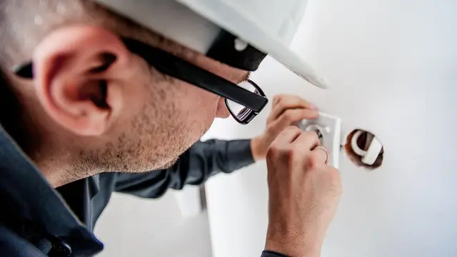Electrician installing a wall outlet