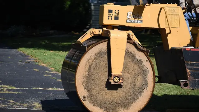 A road roller pressing fresh asphalt
