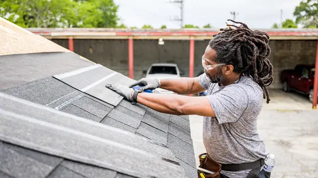 Roofer laying asphalt shingles