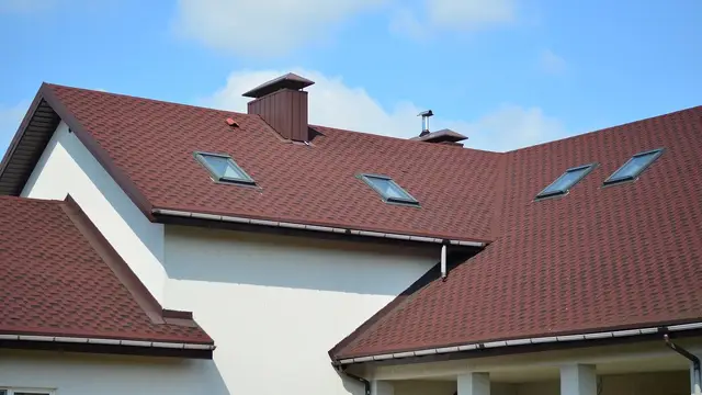 House with a red shingle roof and skylights